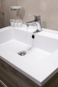 a white bathroom sink with a faucet at Agriturismo Resort Costa House in Lampedusa