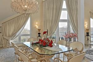 a dining room with a glass table with flowers on it at Penthouse Mülheim- Ruhr - Zentral - Edel - Luxus pur in Mülheim an der Ruhr
