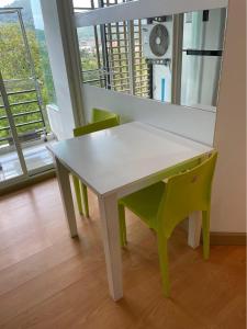 uma mesa branca e cadeiras num quarto com uma janela em Risa Plus2 em Kathu