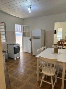 a kitchen with a table and chairs and a refrigerator at Casa próxima ao Centro in Caraguatatuba