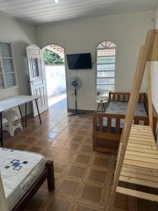 a room with two bunk beds and a tv at Casa próxima ao Centro in Caraguatatuba