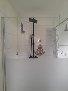a bathroom with a glass shower stall with a wheel on the wall at Ferienhaus im Grünen in Wendorf
