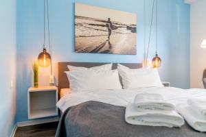 een slaapkamer met een bed met twee handdoeken erop bij Hotel dat Norden in Horumersiel