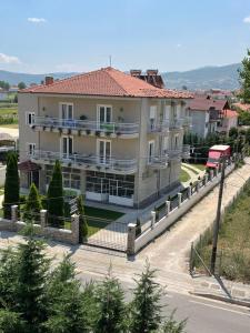 een groot wit gebouw met een hek eromheen bij Rent Rooms Kapri in Pogradec