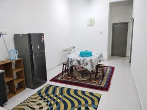 ein Wohnzimmer mit einem Tisch und einem Teppich in der Unterkunft AqilD Homestay in Jasin