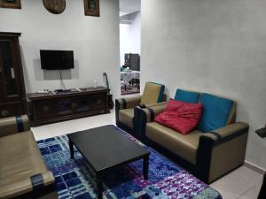 ein Wohnzimmer mit 2 Sofas und einem TV in der Unterkunft Homestay Rim Baru in Jasin