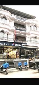a building with three scooters parked in front of it at HOTEL BREEZE NEW JALPAIGURI in Siliguri