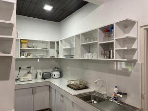 eine Küche mit weißen Schränken und einem Waschbecken in der Unterkunft Nature Korale in Galle