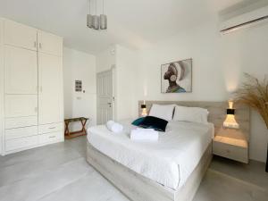 レティムノ・タウンにあるSunset Seaside Apartments & Studiosの白いベッドルーム(大きな白いベッド付)