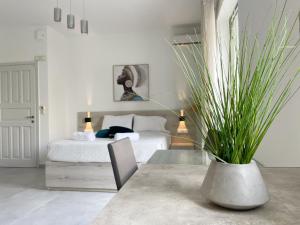 レティムノ・タウンにあるSunset Seaside Apartments & Studiosのベッドルーム1室(ベッド1台付)、花瓶1本(植物付)