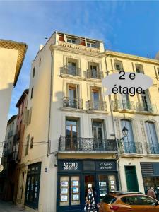 ein Gebäude mit einem Laden an der Seite in der Unterkunft Appartement de charme avec balcon au pied des commerces in Béziers