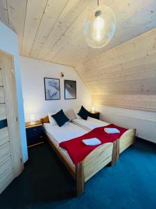 a bedroom with a large bed with a red blanket at Willa Sasanka in Duszniki Zdrój