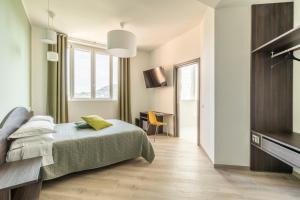 Dormitorio con cama, escritorio y TV en Salsomaggiore Golf Guest House en Salsomaggiore Terme