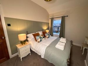 1 dormitorio con 1 cama con lámpara y ventana en Beautiful, Relaxing Home in Central Saltaire en Saltaire