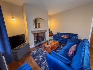 a living room with a blue couch and a fireplace at Beautiful, Relaxing Home in Central Saltaire in Saltaire