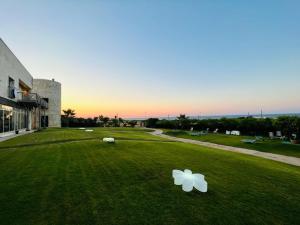 zwei weiße Objekte auf dem Gras vor einem Gebäude in der Unterkunft Hotel Scoglio Degli Achei in Torre Santa Sabina