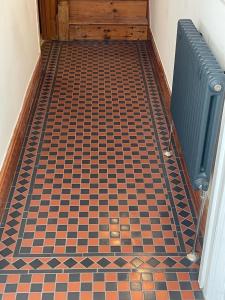 a hallway with a checkered floor and a radiator at Seaside holiday home in Exmouth