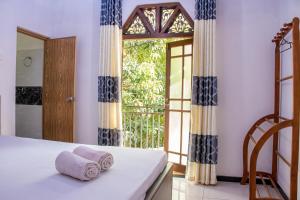 a bedroom with a bed and a large window at DiNi Galle in Galle