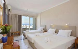a hotel room with two beds and a balcony at Kumba in Nea Chora in Chania Town