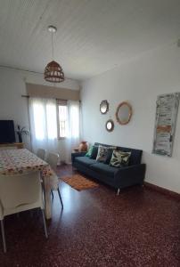 uma sala de estar com um sofá azul e uma mesa em Casa y monoambiente para 8 patio y 3 garaje - Tangará em Posadas