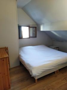 a bedroom with a white bed with a window at Évasion Hébergement in Allevard