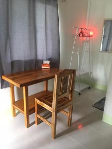 een houten tafel en een stoel met een bureau en een lamp bij World Citizen GuestHouse in Ko Pha Ngan