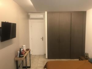 1 dormitorio con cama, armario y TV en A Casa Assulanatta en Santa-Reparata-di-Balagna