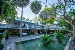 a hotel with a pool in front of a building at Zantiis Ndol Villas in Muak Lek District