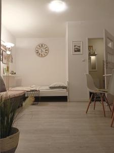 um quarto com uma cama e um relógio na parede em Apartament pod Chełmcem em Szczawno-Zdrój