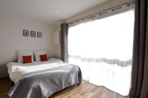 um quarto com uma cama e uma grande janela em Studio Central 300 m des plages, au calme em Cannes