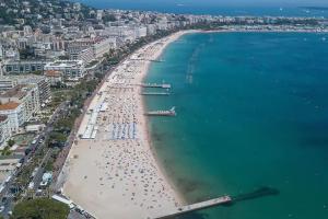 uma vista aérea de uma praia com uma multidão de pessoas em Studio Central 300 m des plages, au calme em Cannes