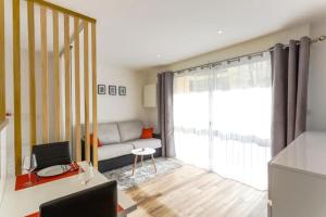 uma sala de estar com um sofá e uma janela em Studio Central 300 m des plages, au calme em Cannes