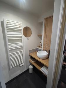 La salle de bains est pourvue d'un lavabo blanc et d'un miroir. dans l'établissement Le Havre, 1 chambre , appartement Sympa en centre ville, au Havre