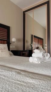 a bedroom with a large bed with towels on it at Hospedería Nieves Centro in Chipiona