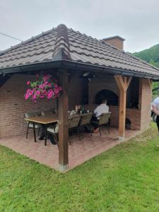 a pavilion with a table and chairs under a roof at Apartman Nikolina in Bajina Bašta