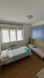 a bedroom with two beds and two windows at Civico 32 in Montalto Dora