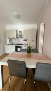 a kitchen with a dining table with chairs and a kitchen withermottermott at Civico 32 in Montalto Dora +35 photos