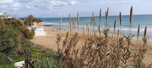 アヴォラにあるKrizia Mareの砂浜と海の上に建つ白い小屋があるビーチ