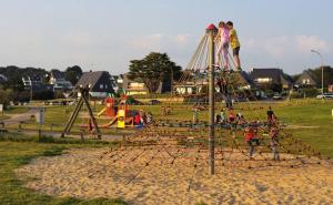 un gruppo di bambini che giocano in un parco giochi di Vacances face à la mer! a Guidel