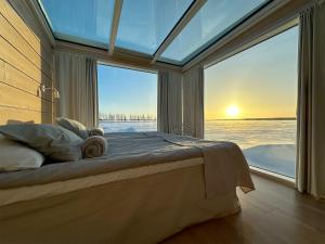 a bedroom with a bed in front of a large window at Seaside Glass Villas in Kemi