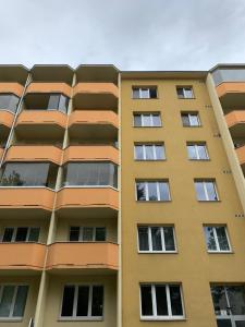 a tall yellow building with many windows at Stilvolle Stadtoase in Brno