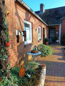a brick house with a patio with a table at Ferienhaus Bonishof in Westerholt