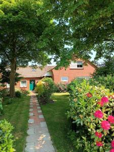 a garden with a brick house and some flowers at Ferienhaus Bonishof in Westerholt