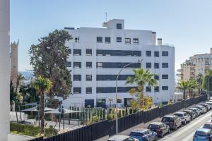 une longue ligne de voitures garées devant un bâtiment dans l'établissement Barquilla Apartment - Kura Homes, à Marbella