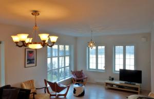 a living room with chairs and a tv and windows at Flørli 4444 Lysefjorden - Director's residence in Sandnes
