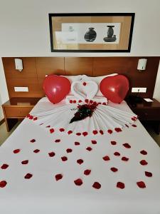 a bed with a bunch of hearts on it at Europeia Hotel in Caldas da Rainha