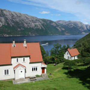 a white house with an orange roof next to a lake at Flørli 4444 Lysefjorden - Director's residence in Sandnes