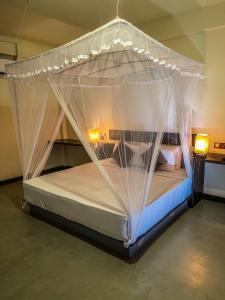 a bed with mosquito netting in a room at Lankapura Heritage in Sigiriya