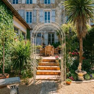 einen Torbogen vor einem Haus mit Garten in der Unterkunft La Maison 64 Chambre D'Hôtes in Barbaste