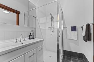 baño blanco con ducha y lavamanos en Diamond Lake Escape en Collie